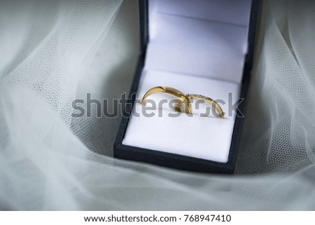 Golden wedding rings in a beautiful black box on a white background.