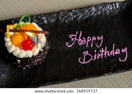 close-up happy birthday cake on black plate