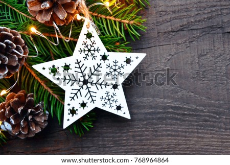 Christmas decoration with fir tree, garland lights and white christmas star on old wooden background. Winter holidays,Merry Christmas, Happy New Year concept.Copy space.