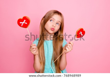 So cute, lovely and funny! Portrait of beautiful sweet girl wearing light blue dress, she is dreaming about confectionery and pastry, isolated on bright pink background