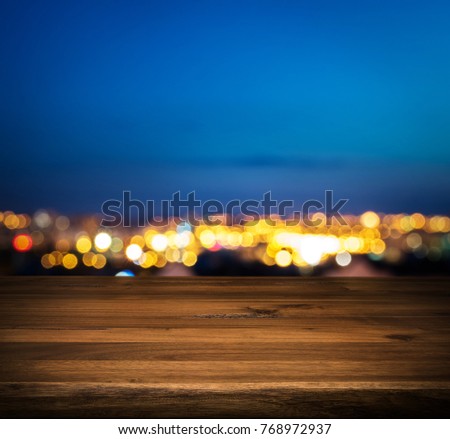 Wood table top on night city background.