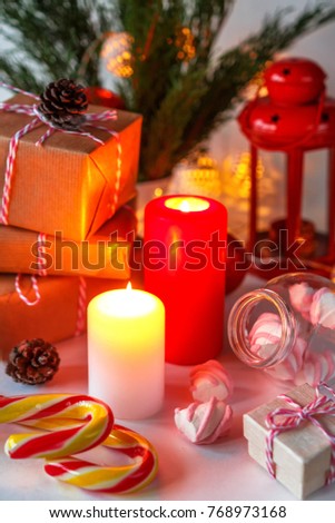 Christmas decor of a candle, gifts, marshmallow in a festive atmosphere background with copy space