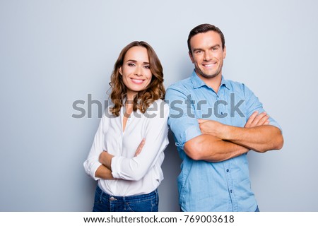 He vs she happy together. Close up portrait of attractive, caucasian, lovely, cute, adult couple in casual outfit  looking at camera standing with crossed arms over grey background Royalty-Free Stock Photo #769003618
