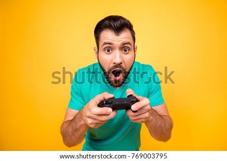 I am number one in playing games! Close up portrait of funny joyful cheerful happy guy, he is rejoicing his victory with gamepad in hands, isolated on bright yellow background