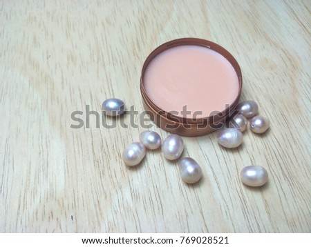 A circular perfume on a brown wooden background.