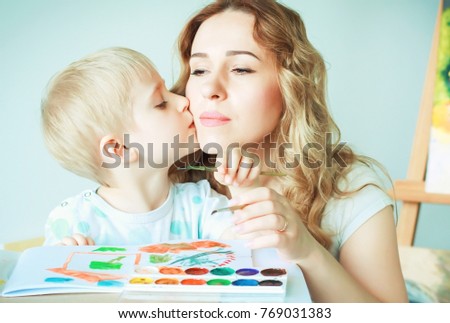 Teaching drawing and painting for children. Mom and her young son draw with watercolor, selective focus. Preschool education