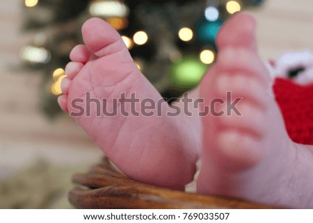 Close up of baby feet in front of Christmas tree.