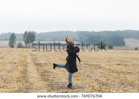Picture of happy cheerful woman having fun on wheat field, beautiful brunette with raised up hands enjoying freedom outdoors, agriculture lifestyle, autumn harvest concept, fall season