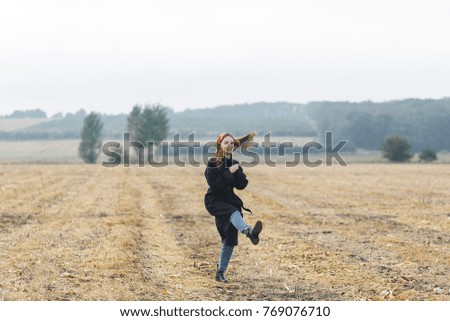 Picture of happy cheerful woman having fun on wheat field, beautiful brunette with raised up hands enjoying freedom outdoors, agriculture lifestyle, autumn harvest concept, fall season