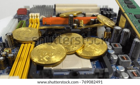 several coins of bitcoins and a strip of electronic memory on a light background