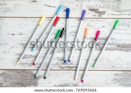 Colorful  dispersed felt tip pens on white wooden background