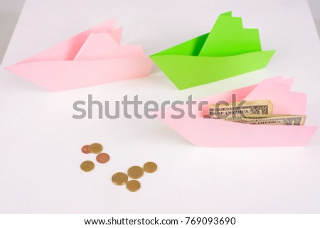 Business concept, 3-paper boats sailing forward and money on Board, a few coins ahead