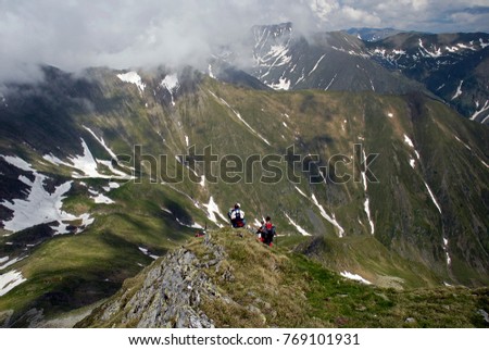 Mountaineers hiking in the Southern Carpathian Mountains and the Moldoveanu peak in the backgorund