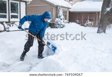 Man Removal Snow with a Shovel Royalty-Free Stock Photo #769104067
