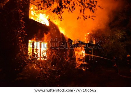 fire in the house at night. Firefighters extinguish a large-scale fire in a private house at night
