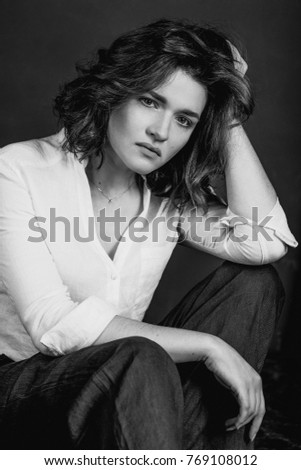 Black and white portraite of young, beautiful sad woman actress with short brown hair in the studio