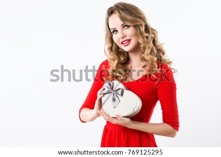 Beautiful woman in a red dress with a gift box in the shape of a heart. Isolated.