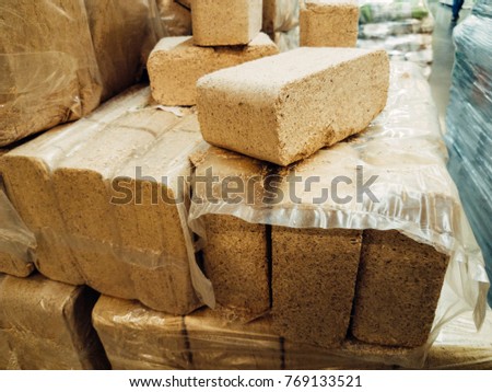 Alternative fuel, eco fuel, bio fuel. Wood sawdust briquettes for stoves. Lean-burn with good heat output. Briquettes from sawdust on a green background. Royalty-Free Stock Photo #769133521