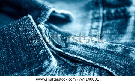 Denim clothes lying on the table with the glasses. Blue jeans