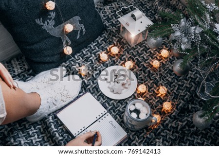 Writing goals for the next year with a cup of chocolate under the Christmas tree
