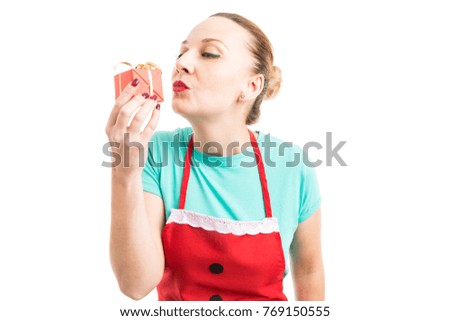 Happy woman wearing red apron and kissing gift or present isolated on white copy space background