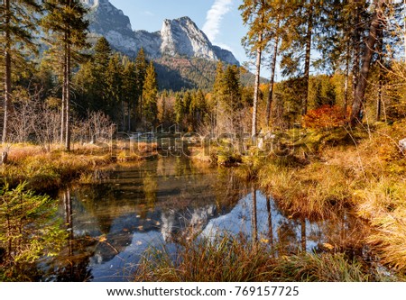 Unsurpassed Autumn Sunny Landscape. Awesome alpine highlands in sunny day. impressively beautiful Hintersee lake with Colorful trees and blue sky. Unsurpassed sunrise in mountains. Instagram Filter