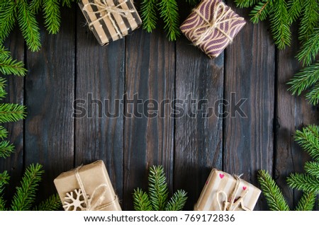Christmas still life with gifts on a black wooden background with a Christmas tree. New Year gifts