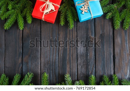 Christmas still life with gifts on a black wooden background with a Christmas tree. New Year gifts
