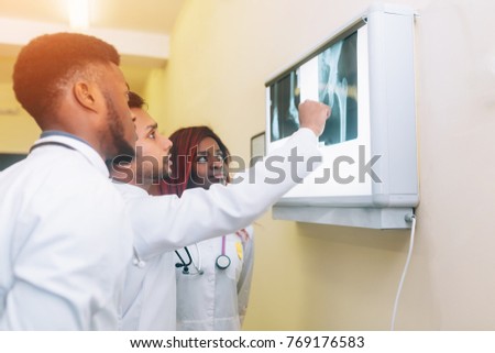 Multiracial team of young doctors looking at x-ray healthcare, medical and radiology concept