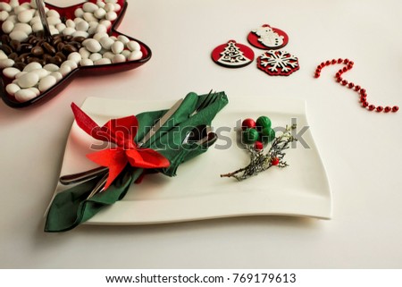 Classy cutlery in special folded paper napkin on luxury white porcelain plate.Christmas or new year table setting.Close up taken.