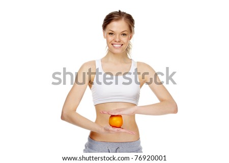 Image of young healthy woman holding an orange in front of belly