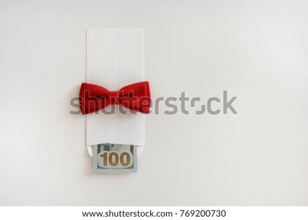 money in a white gift envelope with a red bow on a white background