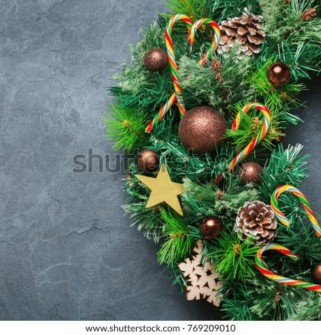 Holidays new year concept. Advent christmas door wreath with festive decoration on a cozy black background. Copy space flat lay top view