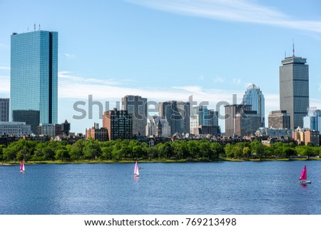 Boston river skyline with pink sail boats and kayaks