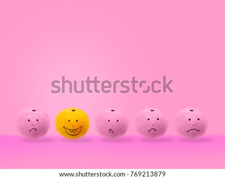 Pink oranges drawing the face is not happy. are placed in a row on pink pastel backgroud, with one orange drawing Smiley face distinguished by another.Outstanding minimal concept