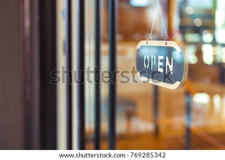 Open sign board hanging on the Glass Door