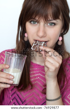 Young beautiful brunette eating cookies