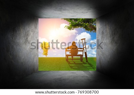Silhouette of disabled women or axillary crutches under the tree stay outside a room with dark concrete walls on have tree  sunrise background. International Disability Day or Handicapped sport.
