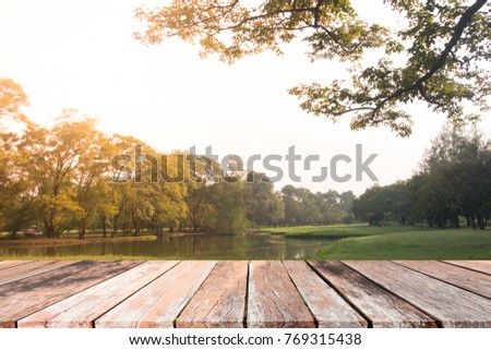 Natural wood table with sun light in the lake park.