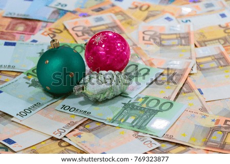 a pile of paper euros and Christmas toys