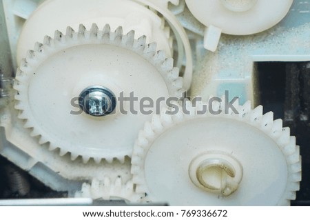 Two white gears connected in the device.