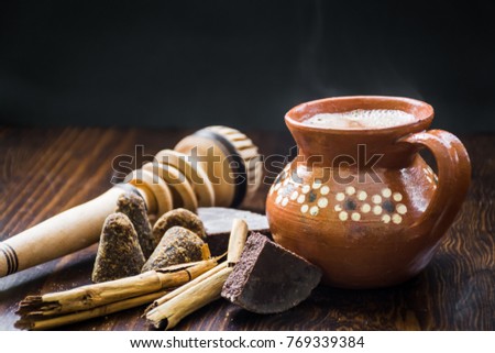 Mexican hot cocoa with ingredients and traditional wooden whisk Royalty-Free Stock Photo #769339384