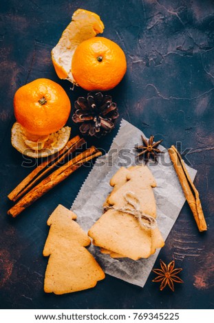Christmas cookies and oranges mandarins on dark background