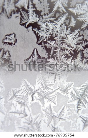 Winter on the window glass, vertical photo.