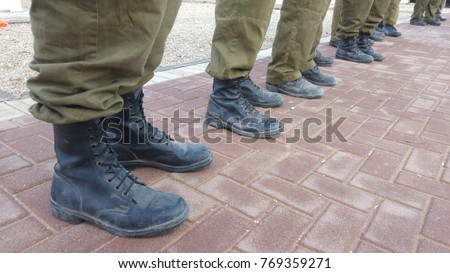 Israel Defense Force reserve duty soldiers standing outside, only their feet seen with military boots. IDF, Israeli soldiers stock image. Royalty-Free Stock Photo #769359271