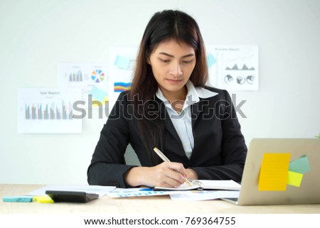  Close up of business woman  office work sitting at table and writing on notebook 
