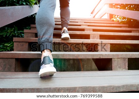 A man step up to success, sport man is climbing on wooden step Royalty-Free Stock Photo #769399588