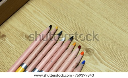 Wooden colored pencils on wooden background