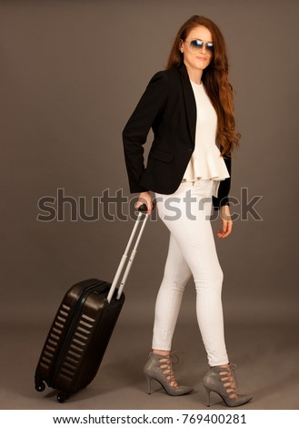 attractive busienss woman with suitcase - business travel studio conceptual photography