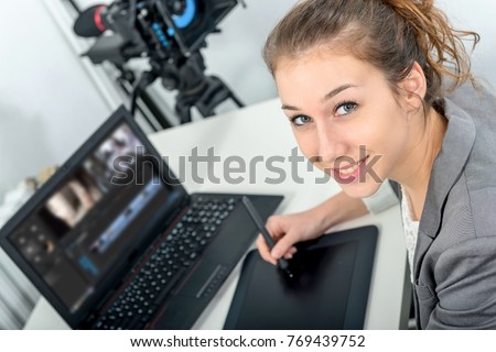 a young woman designer using graphics tablet for video editing